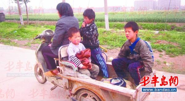 2011年底一名孩子在三輪車上趕作業。一年半過去了，這樣的場景仍隨處可見。