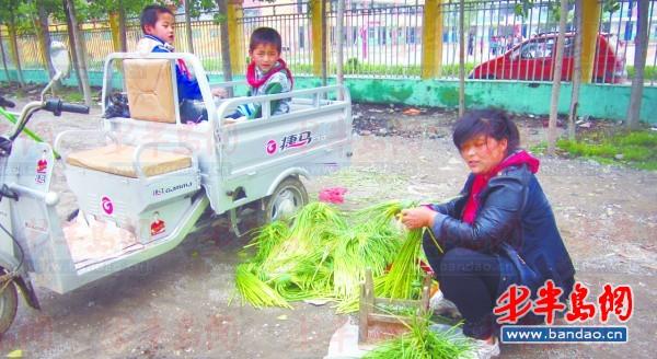 2011年底一名孩子在三輪車上趕作業。一年半過去了，這樣的場景仍隨處可見。